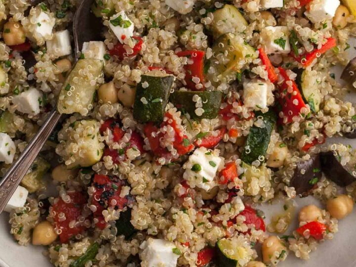 quinoa salad with roasted zucchini, eggplant and red peppers close up on plate