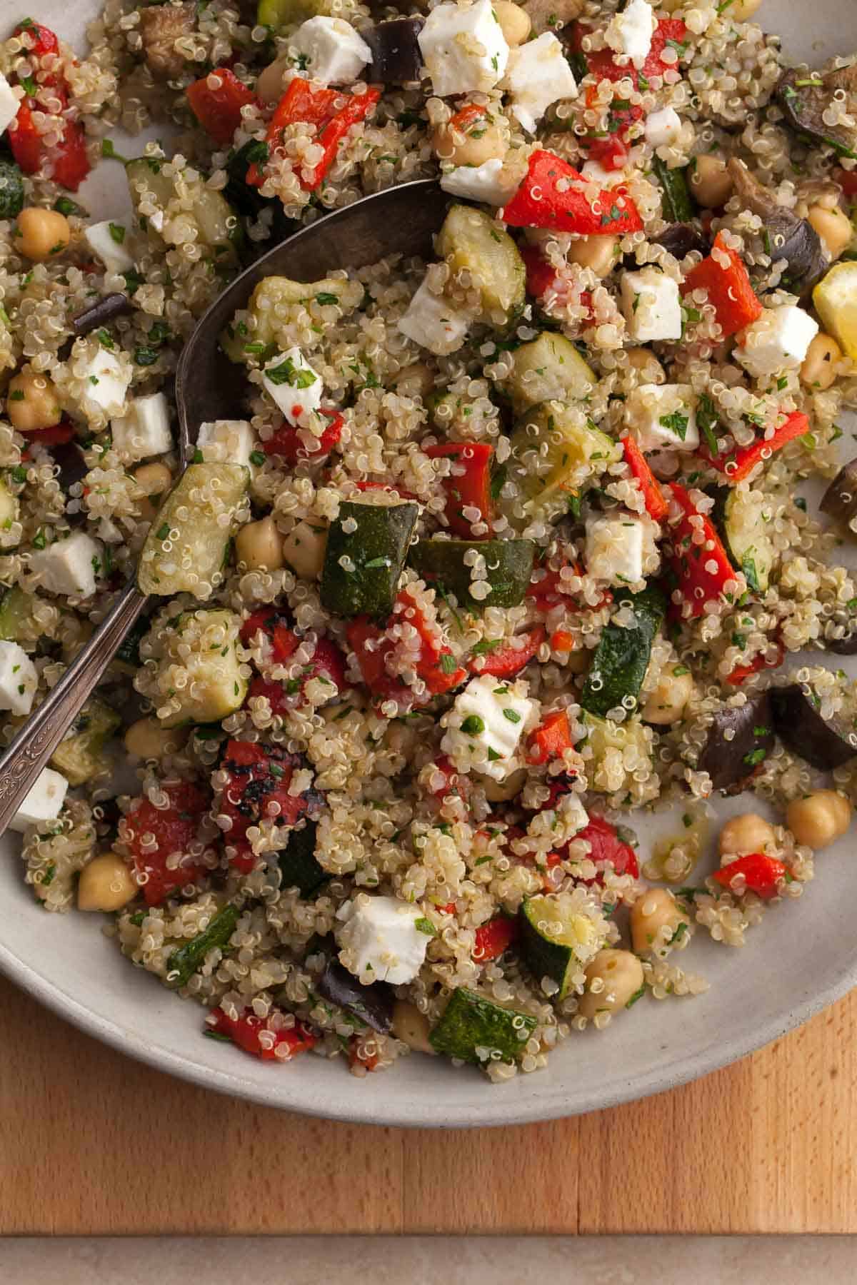 quinoa salad with roasted zucchini, eggplant and red peppers close up on plate
