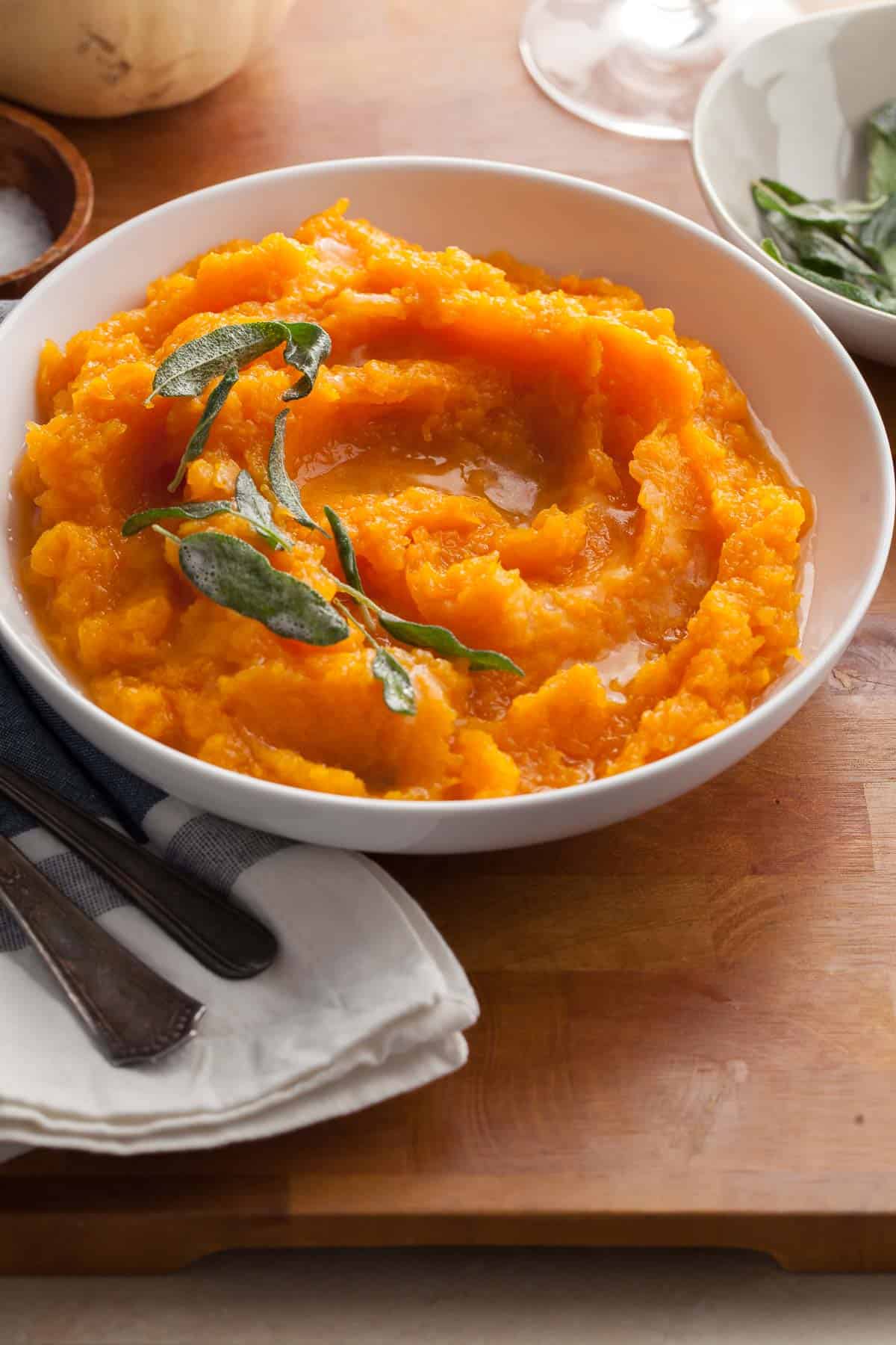 Mashed Butternut Squash with Brown Butter in bowl topped with sage